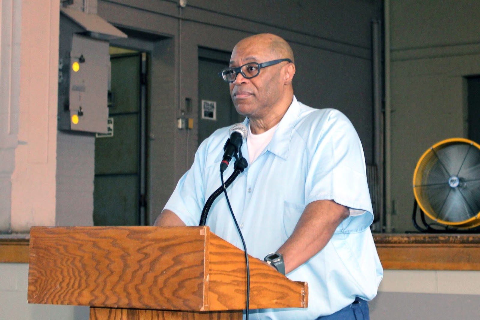 Robert Maury stands at a podium speaking at the Stateville Veterans Group’s Remembrance and Rights